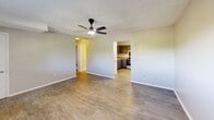 Located at 220 Culver St in Red Bank, TN, this two-bedroom, one-bathroom home offers a practical and well-organized single-floor layout. The living room features durable hardwood-style flooring, neutral-toned walls, a textured ceiling, and a ceiling fan with integrated lighting. Natural light filters in through a window fitted with blinds, and a wall-mounted AC unit provides climate control. The open sightlines connect the living room directly to the kitchen, which is outfitted with gray cabinetry, a granite-style countertop, a double stainless steel sink, and stainless steel appliances including a range and refrigerator. A window above the sink adds additional natural light to the space. Both bedrooms are carpeted and feature ceiling fans, closet storage with bi-fold doors, and windows with blinds. The hallway connects the main living areas to the bedrooms and bathroom. The bathroom is clean and functional, with a tub-shower combination, a window for ventilation, and light wood-style flooring. Textured ceilings are consistent throughout the home, contributing to a cohesive aesthetic across all rooms.