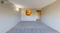 Located at 24 Oyster Bay Road in Boston's Dorchester neighborhood, this single-floor unit offers a functional and comfortable layout with a neutral color palette throughout. The living area is generously proportioned, featuring soft wall-to-wall carpeting and a large sliding glass door that opens onto a private balcony. The balcony overlooks mature trees, providing a pleasant, nature-filled outlook and allowing abundant natural light to fill the room.

The kitchen is efficiently designed with warm-toned wooden cabinetry, light countertops, a built-in dishwasher, and tile flooring. A distinctive pass-through window connects the kitchen to the living area, creating an open, communicative feel between the two spaces while maintaining a defined layout.

The bedroom is a comfortable, carpeted room with a sizable closet featuring built-in shelving. A well-placed window frames views of surrounding greenery, continuing the natural aesthetic found throughout the unit. The bathroom is clean and straightforward, equipped with a full tiled tub-shower combination and classic fixtures.

Overall, the unit presents a practical and cohesive living environment with consistent neutral tones, carpeted comfort in living and sleeping areas, and a connection to the outdoors through its balcony and tree-framed windows.