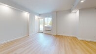 Located at 229 Willett Ave in Port Chester, NY, this thoughtfully designed 2-bedroom, 1-bathroom residence offers a clean, modern aesthetic throughout its well-proportioned single-floor layout. Light wood flooring flows seamlessly across every room, complementing the crisp white walls and recessed lighting that create a bright, welcoming atmosphere.

The open-concept kitchen and living area serves as the heart of the home. The kitchen is outfitted with sleek white cabinetry, a marble-style tile backsplash, stainless steel appliances, and a striking peninsula island accented with slatted wood paneling and a white quartz countertop — a refined focal point that anchors the space.

The spacious living area features large windows that invite natural light and offer views of the surrounding neighborhood. The generously sized primary bedroom also benefits from natural light via a window with outdoor views, while the second bedroom is similarly bright and well-proportioned. Two closets provide practical storage throughout the unit.

The bathroom presents a refined, spa-like design with large-format light gray stone-look tile covering the walls and floors, a white vanity with black hardware fixtures, an extended mirror, and a soaking tub with a wall-mounted faucet. A hallway connects all rooms with ease, completing this modern and move-in-ready residence.
