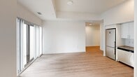Located at 375 South Street in London, Ontario, this modern 2-bedroom, 1-bathroom unit offers a thoughtfully designed layout with a clean, contemporary aesthetic. The open-concept living area is bathed in natural light, courtesy of large floor-to-ceiling windows dressed with vertical blinds, and features light wood laminate flooring that flows seamlessly throughout the space. The kitchen, visible from the main living area, is equipped with white cabinetry, stainless steel appliances including a refrigerator and oven, and a functional layout that makes efficient use of the available space.

Both bedrooms are bright and well-proportioned, with the primary bedroom offering large windows that frame views of the surrounding London cityscape. Built-in sliding closets provide practical storage solutions, while the clean white walls and light flooring maintain a consistent, airy feel across all rooms.

The bathroom is finished with large-format grey tile flooring, a full soaker tub and shower combination, a wall-mounted storage cabinet, and a vanity with a mirror — all presented in a crisp, white palette. A connecting hallway ties the layout together efficiently.

This unit presents a modern, move-in-ready living space ideal for those seeking a clean, functional home in an urban London, Ontario setting.