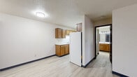Located at 175 S National Ave in Fond du Lac, Wisconsin, this one-bedroom, one-bathroom unit offers a practical and comfortable single-floor layout. Light-toned luxury vinyl plank flooring runs throughout, providing a clean, cohesive aesthetic across the entire space.

The galley-style kitchen is efficiently designed, featuring warm oak cabinetry on both upper and lower levels, generous counter space with white countertops, a double-basin sink, and white appliances including a refrigerator, range, and oven. Overhead cabinetry extends to the ceiling, maximizing storage capacity.

The open living area adjoins the kitchen and benefits from a textured ceiling and flush-mount lighting, creating a simple, functional atmosphere. The bedroom is a comfortable size, offering two windows dressed with horizontal blinds that allow natural light to filter in. A baseboard heating unit runs along the wall, ensuring warmth throughout cooler months.

The bathroom is accessed via a short hallway and includes a vanity with oak cabinetry, a full bathtub with a shower, and a toilet. Dark-framed doorways throughout the unit add a subtle contrast to the light walls and flooring.

Overall, the unit presents a clean, move-in-ready environment with a straightforward, no-frills design suited for everyday living.