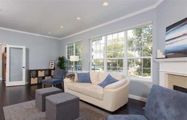 Living room with large windows overlooking serene Wilkins Ave - 10640 Wilkins Ave
