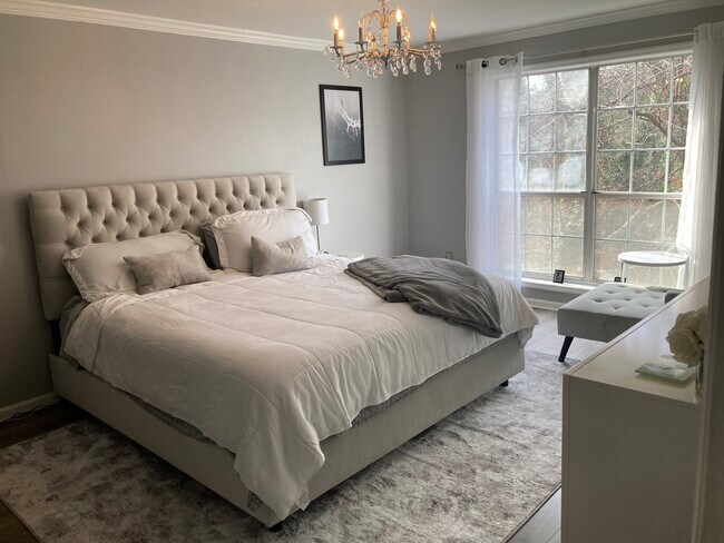 Precioso dormitorio principal de grandes dimensiones con una amplia ventana con vistas a un hermoso paisaje natural. - 2901 Lenox Rd NE