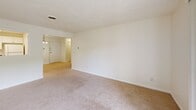 Located at 33 Highland Glen Dr in Randolph, MA, this 2-bedroom, 1-bathroom residence offers a practical and comfortable single-floor layout. The combined kitchen and living room area forms the heart of the home, with the living room featuring soft carpeted flooring, neutral cream-toned walls, and a sliding glass door that opens to a private outdoor deck with pleasant views of surrounding greenery. A chandelier-lit entryway connects the main living spaces seamlessly.

The kitchen is well-appointed with white cabinetry, blue-grey laminate countertops, a tile backsplash, and white appliances including a coil-burner range and full-size refrigerator. A pass-through window above the counter brings in natural light and outdoor views, while durable wood-look flooring grounds the space.

Both bedrooms are carpeted and bathed in natural light through large windows overlooking lush trees. The generously sized primary bedroom includes a wide closet with wire shelving for ample storage. The full bathroom features a white vanity with under-cabinet storage, a framed mirror, and a multi-bulb vanity light fixture, all set on herringbone wood-look flooring. The overall aesthetic is clean, bright, and move-in ready.