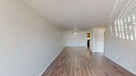 This 690 square foot apartment in Summit West offers a thoughtful blend of comfort and functionality. The single-floor layout comprises one bedroom, one bathroom, and an open-concept living area. The space boasts modern finishes throughout, with sleek wood-look flooring that unifies the entire apartment.

The living room is bright and airy, featuring a large window that floods the space with natural light. This area seamlessly connects to the kitchen, creating an ideal space for entertaining or relaxing. The kitchen, while compact, is well-equipped with wooden cabinetry, a full-sized refrigerator, and ample counter space for meal preparation.

The bedroom, measuring 180 square feet, offers a cozy retreat with built-in closet space for storage. The bathroom features a dual-sink vanity with a large mirror, providing a touch of luxury to the space. An in-unit laundry area with a washer and dryer adds convenience to daily life.

Throughout the apartment, neutral-toned walls and textured ceilings create a canvas for personalization. The overall design prioritizes functionality without sacrificing style, making efficient use of the available square footage. This apartment is well-suited for individuals or couples seeking a modern, low-maintenance living space in a prime location.