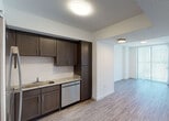Located at 11855 SW 216th St in Miami, FL, this single-floor residence offers a clean, contemporary design with a cohesive aesthetic throughout. The open-concept kitchen is well-appointed with dark espresso cabinetry, granite countertops, a subway tile backsplash, and a full suite of stainless steel appliances including a refrigerator, electric range, microwave, and dishwasher. The kitchen flows naturally into the living area, which is bathed in natural light courtesy of a floor-to-ceiling sliding glass door fitted with vertical blinds, offering views of the surrounding greenery. Wood-look luxury vinyl flooring runs throughout the main living spaces, providing a warm and durable foundation. The bedroom is a comfortable, well-lit room featuring a ceiling fan, a window with horizontal blinds that frame outdoor views, and easy access to the rest of the unit. The bathroom is finished with matching granite countertops, a dark wood vanity, a large wall mirror, tile flooring, and a shower-tub combination. Textured ceilings and clean white walls create a bright, neutral canvas throughout the unit, making it easy to personalize. Overall, this Miami residence delivers a modern, functional layout with quality finishes in a convenient South Florida location.