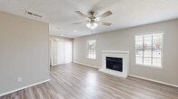 Located at 951 Turner Rd in Grapevine, TX, this single-story, 2-bedroom, 1-bathroom home offers a well-organized layout across a comfortable footprint. The living room serves as the heart of the home, showcasing light wood-style flooring, a classic white brick fireplace, a ceiling fan with light kit, and a textured ceiling. Natural light filters in through slatted blinds on multiple windows, while sliding glass doors provide access to the outdoors. The kitchen is equipped with white cabinetry, white quartz-style countertops, stainless steel appliances including a refrigerator and dishwasher, and a separate pantry for additional storage. Both bedrooms are finished with plush carpet and ceiling fans, offering a comfortable and quiet retreat. The primary bedroom is generously sized and connects to a walk-in closet outfitted with built-in shelving and hanging rods. The full bathroom features a tub-shower combo with white tile surround, a white vanity with an undermount sink, and wood-style flooring. A second closet provides further storage versatility throughout the home. Neutral tones are carried consistently throughout, giving the space a clean and cohesive aesthetic.