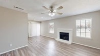 Located at 951 Turner Rd in Grapevine, TX, this single-story, 2-bedroom, 1-bathroom home offers a well-organized layout across a comfortable footprint. The living room serves as the heart of the home, showcasing light wood-style flooring, a classic white brick fireplace, a ceiling fan with light kit, and a textured ceiling. Natural light filters in through slatted blinds on multiple windows, while sliding glass doors provide access to the outdoors. The kitchen is equipped with white cabinetry, white quartz-style countertops, stainless steel appliances including a refrigerator and dishwasher, and a separate pantry for additional storage. Both bedrooms are finished with plush carpet and ceiling fans, offering a comfortable and quiet retreat. The primary bedroom is generously sized and connects to a walk-in closet outfitted with built-in shelving and hanging rods. The full bathroom features a tub-shower combo with white tile surround, a white vanity with an undermount sink, and wood-style flooring. A second closet provides further storage versatility throughout the home. Neutral tones are carried consistently throughout, giving the space a clean and cohesive aesthetic.
