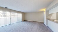 Located at 399 S Grant Ave in Columbus, Ohio, this single-floor unit offers a practical and comfortable layout across a well-proportioned floor plan. The combined kitchen and living room serves as the heart of the space, with the kitchen featuring white cabinetry with wood-tone accents, a double stainless steel sink, ample counter space, and a coil-top electric range with an overhead ventilation hood. A pass-through counter visually connects the kitchen to the living area, enhancing the open feel of the space. The living room is generously sized, finished with plush gray carpeting and neutral beige walls that create a calm, versatile atmosphere. A large sliding glass door fitted with vertical blinds floods the room with natural light and provides outdoor views, while wall-mounted sconce lighting adds a warm ambiance. The full bathroom includes a single-sink vanity with a wide mirror, a combination tub and shower, and wood-look vinyl flooring for a clean, modern touch. A dedicated laundry area accommodates a stacked washer and dryer unit, adding everyday convenience. The hallway connects all areas smoothly, completing a thoughtfully arranged and functional layout suited for comfortable urban living in the heart of Columbus.