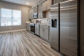 Located at 1705 Henegar Circle in Chattanooga, Tennessee, this two-story home offers a clean, modern aesthetic throughout. Consistent luxury vinyl plank flooring in a warm wood-tone finish runs through every level, complemented by soft gray walls and crisp white trim that create a cohesive, contemporary feel.

The main level features an open-concept kitchen equipped with gray shaker-style cabinetry, brushed gold hardware, white quartz countertops, a classic subway tile backsplash, and a full suite of stainless steel appliances including a range, microwave, dishwasher, and refrigerator. Natural light filters in through well-placed windows, brightening both the kitchen and adjoining living areas. A half bath is conveniently located on this floor.

Upstairs, the primary bedroom includes a walk-in closet and a private en-suite bathroom with a vanity featuring shaker cabinetry and a white countertop. Additional bedrooms are generously sized, each with ceiling fans and ample closet space. A full shared bathroom with a shower/tub combination and matching gray vanity serves the secondary bedrooms. A dedicated laundry room with side-by-side washer and dryer hookups adds everyday convenience. The staircase features warm wood treads with white risers, adding a refined touch to the home's interior design.