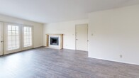 Located in Tulsa, Oklahoma, this 2-bedroom, 1-bathroom residence offers a well-organized single-floor layout designed for comfortable everyday living. The living room serves as the heart of the home, showcasing hardwood-style flooring, a tile-surround fireplace with a wood mantel, and a wall of built-in corner shelving for display or storage. A set of French doors floods the space with natural light and provides outdoor access, while an arched opening connects the living area to a cozy secondary sitting nook with a ceiling fan. The kitchen features warm wood cabinetry, a peninsula breakfast bar, tile flooring, and white appliances including a range, microwave, dishwasher, and refrigerator. Both bedrooms are carpeted and include ceiling fans. The primary bedroom offers a walk-in closet with built-in shelving, while the second bedroom features sliding double-door closet access and a window with outdoor views. A hallway connects the private areas of the home, leading to the full bathroom, which includes a tub-shower combination and tile flooring. Additional built-in corner shelving throughout the unit adds thoughtful storage solutions to the overall layout.