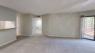Located at Harbor Pointe in Sandy Springs, GA, this one-bedroom, two-bathroom unit offers a practical and comfortable layout across a single floor. The combined kitchen and living room serves as the heart of the home, featuring a peninsula with granite-style countertops, white cabinetry, stainless steel refrigerator, and an electric range — all opening to the carpeted living area, which is bathed in natural light from a sliding glass door that leads to a private balcony. A ceiling fan overhead adds comfort to the living space. The bedroom is generously sized, featuring soft carpet flooring, natural light from a window with blinds, and access to a closet. Two full bathrooms serve the unit; one includes wood-look vinyl flooring, a vanity with dark countertops, white cabinetry, and a tub/shower combo. Additional highlights include two closets for ample storage, a dedicated pantry, and an in-unit laundry area. Throughout the unit, neutral gray walls and textured ceilings create a clean, cohesive aesthetic. The layout is efficient and well-organized, making practical use of every space available.