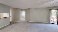 Located at Harbor Pointe in Sandy Springs, GA, this one-bedroom, two-bathroom unit offers a practical and comfortable layout across a single floor. The combined kitchen and living room serves as the heart of the home, featuring a peninsula with granite-style countertops, white cabinetry, stainless steel refrigerator, and an electric range — all opening to the carpeted living area, which is bathed in natural light from a sliding glass door that leads to a private balcony. A ceiling fan overhead adds comfort to the living space. The bedroom is generously sized, featuring soft carpet flooring, natural light from a window with blinds, and access to a closet. Two full bathrooms serve the unit; one includes wood-look vinyl flooring, a vanity with dark countertops, white cabinetry, and a tub/shower combo. Additional highlights include two closets for ample storage, a dedicated pantry, and an in-unit laundry area. Throughout the unit, neutral gray walls and textured ceilings create a clean, cohesive aesthetic. The layout is efficient and well-organized, making practical use of every space available.