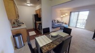 This Classic 2-bedroom, 1-bathroom single-floor residence offers a practical and comfortable layout designed to maximize everyday living. The open-concept living and dining area serves as the heart of the home, where neutral carpet flows seamlessly from the spacious living room—anchored by a sliding glass door that opens to a private balcony with outdoor views—into the dining space, creating a connected and airy feel.

The galley-style kitchen is efficiently designed with warm oak cabinetry providing ample storage, light countertops, a double-basin sink, a dishwasher, and stainless steel appliances including a refrigerator and range. Wood-look flooring in the kitchen adds a classic contrast to the carpeted living areas.

Both bedrooms feature plush carpet and neutral walls. The primary bedroom is notably well-lit, with two large windows that invite natural light and outdoor views. The second bedroom offers a quieter, cozier atmosphere.

The full bathroom includes a shower/tub combination, a single-sink vanity with oak cabinetry, and wood-look flooring, maintaining the classic aesthetic found throughout the residence. The overall ambiance is clean, functional, and well-suited for comfortable everyday living.