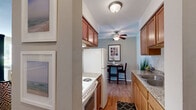 Located at 8848 Goodrich Rd in Bloomington, MN, this well-appointed one-bedroom, one-bathroom residence offers a thoughtfully designed single-floor layout. The open living room is a welcoming centerpiece, showcasing warm hardwood flooring, a bold teal accent wall, a ceiling fan, and large windows that flood the space with natural light and offer pleasant outdoor views of the surrounding greenery. The living area flows naturally into the dining space, creating an open and connected feel throughout.

The kitchen is efficiently designed with rich honey-toned cabinetry, granite countertops, a classic subway tile backsplash, and a double stainless steel sink — offering both style and functionality. Ample cabinet storage adds to its practicality.

The bedroom is a calm retreat, featuring plush carpeting, neutral warm-toned walls, a window with outdoor views, and generous closet space. The bathroom is clean and bright, finished with white subway tile surrounding a full soaking tub and shower combination with polished chrome fixtures.

A connecting hallway ties the layout together seamlessly. Throughout the residence, the consistent use of hardwood flooring, neutral tones, and natural light creates a cohesive, inviting ambiance ideal for comfortable everyday living.