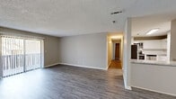 Located at 927 Honeysuckle Rd in Dothan, Alabama, this single-story 2-bedroom, 2-bathroom home offers a practical and comfortable layout. The open living area is finished with durable wood-look flooring and neutral gray walls, creating a clean and versatile backdrop. A textured ceiling runs throughout the main living spaces, adding a classic touch. Sliding glass doors with vertical blinds allow natural light to fill the living room while providing access to the outdoors.

The kitchen features white cabinetry, light stone-look countertops, and a stainless steel refrigerator, with an open pass-through connecting it to the living area for easy flow. A central hallway leads to the private quarters of the home.

Both bedrooms are carpeted for comfort and finished with the same neutral tones found throughout. The spacious primary bedroom includes a walk-in closet with built-in shelving and rod storage, and connects directly to a private en-suite bathroom. The second bedroom is well-sized with its own closet access. The bathrooms feature wood-look vinyl flooring and clean, simple fixtures. A dedicated laundry area completes the functional layout of this well-maintained home.