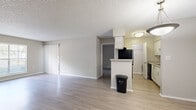 This 2-bedroom, 2-bathroom residence at Avion in Tampa, Florida offers a practical and comfortable single-floor layout. The open-concept living and dining area is finished with light wood-style flooring that extends throughout the main living spaces, creating a bright and cohesive feel. A textured ceiling adds dimension overhead, while windows allow natural light to filter in. The galley-style kitchen features white cabinetry, a subway tile backsplash, light countertops, and black appliances including a range and refrigerator. A peninsula counter separates the kitchen from the living area, adding a functional divide. A dedicated pantry provides additional storage. The primary bedroom is a generously sized, carpeted retreat with a walk-in closet equipped with wire shelving. It connects to a private bathroom featuring a tub/shower combination and a vanity with light countertops. The second bedroom is also carpeted and receives natural light through a window with blinds. A second full bathroom mirrors the clean, functional design of the first. A hallway connects the bedrooms and living areas, with two closets offering ample storage throughout. The unit is located at 11500 N Dale Mabry Hwy, Tampa, FL 33618.