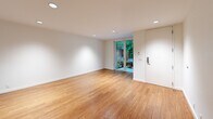 Located in Seattle's vibrant Capitol Hill neighborhood, this one-bedroom, one-bathroom unit at 703 Bellevue Ave E offers a thoughtfully designed layout across a single floor. Warm bamboo hardwood flooring flows consistently throughout the entire space, creating a cohesive and inviting atmosphere.

The open-concept living and kitchen area forms the heart of the unit. The kitchen is outfitted with natural wood cabinetry, dark upper cabinets, white subway tile backsplash, stainless steel appliances including a refrigerator and dishwasher, and a built-in oven. Recessed lighting illuminates the space cleanly. The living area benefits from a sliding glass door that opens to a verdant outdoor setting, allowing abundant natural light and greenery views to fill the room.

The bedroom is a comfortable, well-proportioned retreat featuring a ceiling fan with light, a wide window framing lush tree views, and a set of built-in closet doors providing ample storage. Continued bamboo hardwood flooring maintains the unit's consistent design language.

The bathroom is finished with white subway tile surrounding a full soaking tub and shower, brown mosaic floor tile, a wood-framed vanity with a gray countertop, and a large mirror — delivering a clean, modern aesthetic. The unit's crisp white walls and natural finishes throughout give it a calm, contemporary character.