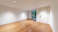 Located in Seattle's vibrant Capitol Hill neighborhood, this one-bedroom, one-bathroom unit at 703 Bellevue Ave E offers a thoughtfully designed layout across a single floor. Warm bamboo hardwood flooring flows consistently throughout the entire space, creating a cohesive and inviting atmosphere.

The open-concept living and kitchen area forms the heart of the unit. The kitchen is outfitted with natural wood cabinetry, dark upper cabinets, white subway tile backsplash, stainless steel appliances including a refrigerator and dishwasher, and a built-in oven. Recessed lighting illuminates the space cleanly. The living area benefits from a sliding glass door that opens to a verdant outdoor setting, allowing abundant natural light and greenery views to fill the room.

The bedroom is a comfortable, well-proportioned retreat featuring a ceiling fan with light, a wide window framing lush tree views, and a set of built-in closet doors providing ample storage. Continued bamboo hardwood flooring maintains the unit's consistent design language.

The bathroom is finished with white subway tile surrounding a full soaking tub and shower, brown mosaic floor tile, a wood-framed vanity with a gray countertop, and a large mirror — delivering a clean, modern aesthetic. The unit's crisp white walls and natural finishes throughout give it a calm, contemporary character.