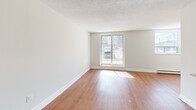 Located at 383 Albert St in Waterloo, Ontario, this 2-bedroom, 1-bathroom unit offers a well-organized and functional layout across a single floor. The open-concept living and dining area is spacious and bright, featuring warm hardwood-style flooring, large sliding and picture windows that draw in generous natural light, and a textured ceiling throughout. The kitchen is thoughtfully designed with rich dark-brown cabinetry, a full suite of stainless steel appliances including a refrigerator, stove, built-in microwave, and dishwasher, complemented by a breakfast bar peninsula that connects it seamlessly to the living area. The primary bedroom is a well-proportioned room with a window and direct access to a dedicated closet space, while the second bedroom also features hardwood-style flooring, a window, and a sliding-door closet for convenient storage. The bathroom is finished with tile flooring, a dark wood vanity with a single sink, a large mirror with overhead lighting, and a full tub-shower combination with tile surround. Clean neutral tones and white trim are consistent throughout, contributing to a bright and cohesive interior aesthetic. The unit also includes an entry closet, adding practical everyday storage.