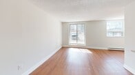 Located at 383 Albert St in Waterloo, Ontario, this 2-bedroom, 1-bathroom unit offers a well-organized and functional layout across a single floor. The open-concept living and dining area is spacious and bright, featuring warm hardwood-style flooring, large sliding and picture windows that draw in generous natural light, and a textured ceiling throughout. The kitchen is thoughtfully designed with rich dark-brown cabinetry, a full suite of stainless steel appliances including a refrigerator, stove, built-in microwave, and dishwasher, complemented by a breakfast bar peninsula that connects it seamlessly to the living area. The primary bedroom is a well-proportioned room with a window and direct access to a dedicated closet space, while the second bedroom also features hardwood-style flooring, a window, and a sliding-door closet for convenient storage. The bathroom is finished with tile flooring, a dark wood vanity with a single sink, a large mirror with overhead lighting, and a full tub-shower combination with tile surround. Clean neutral tones and white trim are consistent throughout, contributing to a bright and cohesive interior aesthetic. The unit also includes an entry closet, adding practical everyday storage.