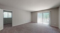 This single-floor apartment at Westwood Manor Apartments in Lindenwold, NJ, offers a practical and straightforward layout across several well-defined living spaces. The living room is generously sized, finished with neutral gray carpet, and features a large sliding glass door fitted with vertical blinds that opens to a private balcony overlooking greenery, allowing natural light to fill the space throughout the day.

The kitchen is equipped with warm wood-toned cabinetry, dark countertops, and white appliances including a gas range, dishwasher, and full-size refrigerator. Light wood-style vinyl flooring extends through the kitchen, providing a clean, easy-to-maintain surface. The kitchen connects directly to the main hallway, facilitating smooth circulation throughout the unit.

The bedrooms are carpeted and finished with neutral tones. One bedroom features a window with exterior views and a standard door opening to the hallway, while another is well-proportioned with a window allowing natural light. Both offer versatile layouts suitable for various furniture arrangements.

The bathroom includes a full-size soaking tub with a shower, a dark-cabinet vanity with a white countertop sink, a framed mirror, and light wood-style vinyl flooring. A window provides natural ventilation and additional light, completing a clean, functional space.