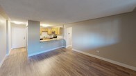 This single-floor unit offers a functional and straightforward layout across several well-defined rooms. The open-concept living area is finished with warm hardwood-style flooring and neutral taupe walls, flowing seamlessly into the kitchen. The kitchen features warm oak cabinetry with ample upper and lower storage, granite-style countertops, stainless steel appliances including a range and over-the-range microwave, and a stainless steel sink. A peninsula counter creates a natural pass-through, connecting the kitchen to the living space.

The bedrooms are finished with plush wall-to-wall carpeting and neutral tones, providing a comfortable and quiet atmosphere. At least one bedroom includes a sliding-door closet with a hanging rod, while baseboard heaters run along the perimeter walls, ensuring efficient warmth. Windows fitted with vertical blinds allow natural light throughout the sleeping areas.

Additional rooms feature hardwood-style flooring consistent with the main living area and include their own baseboard heating. The bathroom is equipped with a tub-shower combination, chrome fixtures, and a frosted privacy window. Textured ceilings are present throughout, adding a consistent finish across the entire space.