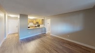 This single-floor unit offers a functional and straightforward layout across several well-defined rooms. The open-concept living area is finished with warm hardwood-style flooring and neutral taupe walls, flowing seamlessly into the kitchen. The kitchen features warm oak cabinetry with ample upper and lower storage, granite-style countertops, stainless steel appliances including a range and over-the-range microwave, and a stainless steel sink. A peninsula counter creates a natural pass-through, connecting the kitchen to the living space.

The bedrooms are finished with plush wall-to-wall carpeting and neutral tones, providing a comfortable and quiet atmosphere. At least one bedroom includes a sliding-door closet with a hanging rod, while baseboard heaters run along the perimeter walls, ensuring efficient warmth. Windows fitted with vertical blinds allow natural light throughout the sleeping areas.

Additional rooms feature hardwood-style flooring consistent with the main living area and include their own baseboard heating. The bathroom is equipped with a tub-shower combination, chrome fixtures, and a frosted privacy window. Textured ceilings are present throughout, adding a consistent finish across the entire space.