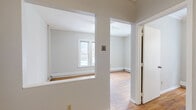 Located at 1821 First Ave S in Minneapolis, MN, this 2-bedroom, 1-bathroom unit offers a practical and well-organized single-floor layout. Warm hardwood flooring runs throughout the main living areas and both bedrooms, lending a classic character to the space. The living room connects to a separate dining area, providing a defined flow between shared spaces. A pass-through window opening between the kitchen and living/dining area adds visual connectivity and a touch of vintage charm.

The kitchen is efficiently laid out with white cabinetry, a granite-style countertop, stainless steel sink, gas range, and a bold black-and-white checkered tile backsplash accent, all complemented by tile flooring and a window for natural light.

Both bedrooms feature hardwood floors and windows that bring in natural light. The primary bedroom offers a closet, while the second bedroom is compact yet functional. Each room is finished with clean white walls and baseboard heating.

The bathroom is neatly appointed with a white vanity, tub/shower combo, and wood-look tile flooring. Two closets provide additional storage throughout the unit. The neutral color palette and classic detailing create a clean, move-in ready environment.
