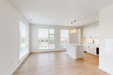 Located at 3600 East-West Hwy in Hyattsville, MD, this well-designed one-bedroom, one-bathroom unit offers a bright and modern living experience. The open-concept layout seamlessly connects the kitchen and living area, where light wood-style flooring and crisp white walls create a clean, contemporary aesthetic throughout. Large windows flood the living space with natural light and frame views of the surrounding cityscape.

The kitchen is a standout feature, outfitted with sleek white cabinetry extending to the ceiling, a herringbone-pattern tile backsplash, quartz countertops, stainless steel appliances including a dishwasher, range, and built-in microwave, and a matte black faucet. A central kitchen island with pendant globe lighting adds both function and style.

The bedroom is a comfortable, well-lit retreat with a window offering outdoor views and access to multiple closets, providing generous storage. The bathroom features marble-look tile flooring, a subway tile tub surround, a white vanity with modern hardware, and a clean, neutral finish throughout. The entrance and additional unclassified room further enhance the unit's functional layout, making it a practical and attractive urban residence.