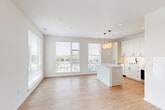 Located at 3600 East-West Hwy in Hyattsville, MD, this well-designed one-bedroom, one-bathroom unit offers a bright and modern living experience. The open-concept layout seamlessly connects the kitchen and living area, where light wood-style flooring and crisp white walls create a clean, contemporary aesthetic throughout. Large windows flood the living space with natural light and frame views of the surrounding cityscape.

The kitchen is a standout feature, outfitted with sleek white cabinetry extending to the ceiling, a herringbone-pattern tile backsplash, quartz countertops, stainless steel appliances including a dishwasher, range, and built-in microwave, and a matte black faucet. A central kitchen island with pendant globe lighting adds both function and style.

The bedroom is a comfortable, well-lit retreat with a window offering outdoor views and access to multiple closets, providing generous storage. The bathroom features marble-look tile flooring, a subway tile tub surround, a white vanity with modern hardware, and a clean, neutral finish throughout. The entrance and additional unclassified room further enhance the unit's functional layout, making it a practical and attractive urban residence.