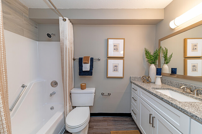 Bright bathroom with granite counters and bathtub - The Fitzgerald