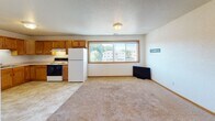 Located at 1311 Pohl Rd in Mankato, Minnesota, this single-floor unit offers a straightforward, functional layout designed for comfortable everyday living. The floor plan reveals a well-organized arrangement of rooms, with the kitchen and living area flowing together in an open configuration that maximizes usable space.

The kitchen is equipped with warm oak cabinetry providing ample upper and lower storage, light-toned countertops, a double stainless steel sink, and includes a refrigerator and electric range. Tile flooring runs throughout the kitchen, transitioning to carpet in the adjacent living area. A large window in the kitchen-living space draws in natural light and offers views of the surrounding neighborhood and mature trees.

The bedrooms are carpeted and feature neutral white walls, wood-trimmed windows that allow natural light to filter in, and wood baseboard trim throughout. At least one bedroom includes a closet with a built-in hanging rod. The bathrooms are clean and functional, each featuring a tub-shower combination, toilet, and a wood-trimmed vanity with tile flooring. Textured ceilings are consistent throughout the unit, contributing to its classic residential character. The overall ambiance is clean, neutral, and move-in ready.