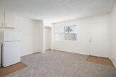 Located at 5525 E Pacific Coast Hwy in Long Beach, California, this one-bedroom, one-bathroom unit offers a well-organized single-floor layout designed to maximize every square foot. The open living area features neutral-toned carpet and light-colored walls, creating a bright and clean atmosphere throughout. A textured ceiling adds a classic residential character to the space.

The kitchen flows directly off the living area and transitions to hardwood-style flooring. It is equipped with white cabinetry — both upper and lower — along with a gas range, double-basin sink, and a full-size refrigerator, providing all essential cooking amenities in a compact, efficient arrangement.

The bedroom is a well-proportioned private retreat, also carpeted, with a window fitted with a wall-unit air conditioner that allows for natural light and personal climate control. A dedicated closet offers convenient built-in storage.

The bathroom features a clean, all-white design with a single vanity, a framed mirror with overhead lighting, a toilet, and a full tub-shower combination with tiled surround. A small window brings in natural light, and hardwood-style flooring ties the room together with a polished finish.

Overall, this unit presents a practical and clean living space suited for individuals or couples seeking a manageable, move-in ready home in Long Beach.