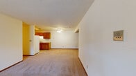 This single-floor residence features 3 bedrooms, 2 bathrooms, and a well-organized layout designed for comfortable everyday living. The open-concept kitchen and living area form the heart of the home, with the kitchen showcasing warm honey-toned wood cabinetry, light countertops, a double sink, a dishwasher, and a full-size refrigerator set on easy-care tile flooring. The adjoining living room is generously proportioned, finished with neutral carpet, and filled with natural light from a large sliding glass door that leads to the outdoors. A ceiling fan provides added comfort to this shared space. The three bedrooms are carpeted and offer clean, neutral walls, with the spacious primary bedroom providing ample room for a full bedroom suite. The two bathrooms include wood-trimmed vanities and a bathtub, reflecting a consistent design language found throughout the home. Warm wood door and trim details tie the interior together, complementing the light-toned walls and carpet. A dedicated closet adds practical storage. Baseboard heating is present throughout, ensuring year-round comfort. The overall ambiance is clean, functional, and move-in ready, making it a practical and accommodating residence.