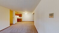 This single-floor residence features 3 bedrooms, 2 bathrooms, and a well-organized layout designed for comfortable everyday living. The open-concept kitchen and living area form the heart of the home, with the kitchen showcasing warm honey-toned wood cabinetry, light countertops, a double sink, a dishwasher, and a full-size refrigerator set on easy-care tile flooring. The adjoining living room is generously proportioned, finished with neutral carpet, and filled with natural light from a large sliding glass door that leads to the outdoors. A ceiling fan provides added comfort to this shared space. The three bedrooms are carpeted and offer clean, neutral walls, with the spacious primary bedroom providing ample room for a full bedroom suite. The two bathrooms include wood-trimmed vanities and a bathtub, reflecting a consistent design language found throughout the home. Warm wood door and trim details tie the interior together, complementing the light-toned walls and carpet. A dedicated closet adds practical storage. Baseboard heating is present throughout, ensuring year-round comfort. The overall ambiance is clean, functional, and move-in ready, making it a practical and accommodating residence.