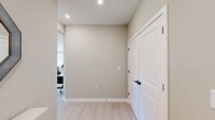 Located at 1 Haddon Blvd in Mount Laurel, NJ, this well-appointed 2-bedroom, 2-bathroom single-floor home offers a thoughtfully designed layout that balances comfort and modern style. The open-concept living and dining area is bathed in natural light from large windows with views of lush greenery, creating a bright and welcoming atmosphere. Light hardwood flooring runs throughout, complementing the neutral, warm-toned walls.

The kitchen is a standout feature, showcasing white shaker cabinetry, a white subway tile backsplash, stainless steel appliances, and a spacious island with a white quartz countertop — ideal for both cooking and casual dining. Pendant and recessed lighting add a polished finish.

The primary bedroom is generously sized, offering outdoor views through wide windows, while the second bedroom is equally comfortable with ample natural light. Each bedroom includes closet storage for added convenience.

The primary bathroom features a wide dual-sink vanity with a wood-toned cabinet, white quartz countertop, and a large mirror with serene outdoor views. The second bathroom offers a full tub-shower combination with clean white subway tile and matte black fixtures. Two hallways provide smooth connectivity throughout the home.