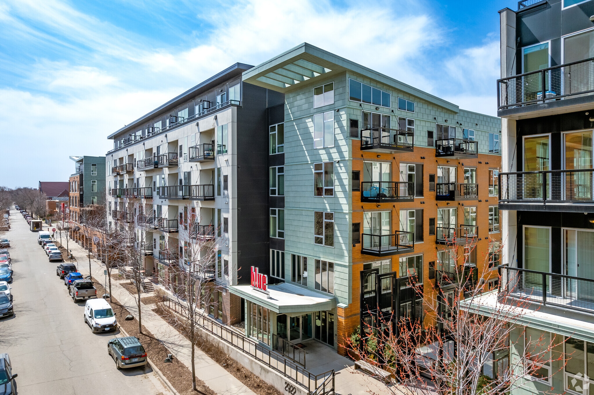 Exterior of a modern apartment building with balconies and large windows.