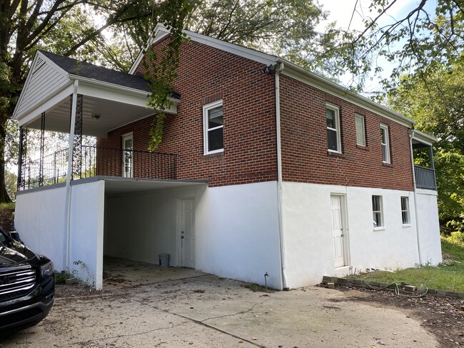 3/4 rear photo showing rear car port, basement entry, and back deck. - 2028 Westover Dr