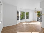 Located at 831 Nobel Dr in Santa Cruz, California, this three-story, two-bedroom, one-bathroom home offers a well-organized layout spread across multiple levels. The ground level features an attached garage with a concrete floor, cinder block walls, and interior stair access leading to the upper floors.

The main living level is bright and welcoming, showcasing light hardwood flooring throughout. The open living room is bathed in natural light through large windows that frame views of the neighborhood's mature trees and streetscape. A pendant light fixture adds a warm, decorative touch. The kitchen is efficiently designed with white shaker cabinetry, white quartz countertops, a stainless steel sink, and stainless steel appliances including a gas range and over-the-range microwave.

The upper floor houses both bedrooms and the full bathroom. The primary bedroom is generously sized, with dual windows inviting abundant natural light and neighborhood views. The second bedroom also features hardwood flooring and a bright window. The shared bathroom is clean and modern, featuring a white vanity with an undermount sink, a mirror, and a tiled shower-tub combination with sliding glass doors. A dedicated closet completes the upper level. The exterior presents a classic façade with a white railed deck/balcony area.