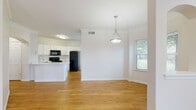 This two-story home offers a thoughtfully designed layout across two levels, combining practical functionality with comfortable living spaces. The attached garage is generously sized, featuring a concrete floor, clean white walls, and an automatic opener — providing ample room for vehicles and storage. The main level showcases an open-concept kitchen equipped with white cabinetry, granite countertops, a large kitchen island, black appliances including a French door refrigerator and electric range, and light hardwood-style flooring. Crown molding accents the ceilings throughout, adding a refined architectural detail to the interior. The upper level features spacious carpeted bedrooms bathed in natural light from multiple windows with exterior views of the surrounding neighborhood. One bedroom includes a walk-in closet, offering practical storage. Ceiling fans are present in the living and bedroom areas, contributing to comfort year-round. The bathrooms are well-appointed with white vanities, granite countertops, tub-shower combinations with tile surrounds, and light hardwood-style flooring. The warm, neutral color palette and consistent finishes throughout the home create a cohesive and inviting ambiance suitable for a variety of lifestyles.