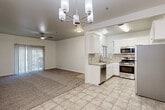 Located at 2851 S Lovers Ln in Visalia, California, this single-story home offers a well-designed, functional layout with a clean, neutral aesthetic throughout. The open-concept living and dining area serves as the heart of the home, where plush carpet in the living space transitions to light tile flooring in the dining area. A modern chandelier with cylindrical shades illuminates the dining space, while a ceiling fan keeps the living area comfortable. Sliding glass doors with vertical blinds provide access to the outdoors.

The kitchen is efficiently arranged and well-equipped, featuring white cabinetry with arched upper door details, a tile backsplash, and a full suite of stainless steel appliances including a gas range, over-the-range microwave, dishwasher, and refrigerator. Light tile countertops and flooring complete the space.

The bedrooms are carpeted and bright, each outfitted with a ceiling fan and ample closet space, including sliding and hinged closet doors with built-in shelving. The bathrooms feature tile flooring, white vanity cabinetry, stone-toned countertops, and large mirrors. The overall ambiance is light, clean, and move-in ready.