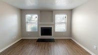 Located at 4400 Holiday Hill Rd in Midland, Texas, this two-story residence offers a practical and comfortable layout with a clean, neutral aesthetic throughout. The living room serves as a central gathering space, highlighted by a white-trimmed fireplace flanked by two windows that allow natural light to fill the room. Hardwood-style flooring and a textured ceiling add character to the space, while the open layout provides a welcoming atmosphere.

The kitchen is designed for functionality, featuring gray cabinetry, dark granite-style countertops, and a full suite of black appliances including a refrigerator, range, microwave, and dishwasher. Ample cabinet storage and counter space make this kitchen well-suited for everyday use.

The bedrooms are carpeted for comfort and each include windows fitted with blinds, providing natural light and privacy. The neutral wall tones create a calm, versatile setting.

The bathroom features a generous vanity with dark speckled countertops, gray cabinetry, a large mirror with overhead lighting, and a clean white tub-shower combo. Hardwood-style flooring ties the bathroom seamlessly to the rest of the home's design. Overall, the space presents a well-maintained and cohesive interior suitable for comfortable living.