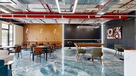 This single-floor open-plan lounge and amenity space delivers a bold industrial-modern aesthetic that is both visually striking and highly functional. The most dramatic feature is the expansive, high-gloss epoxy floor with swirling blue and grey tones that mimics polished marble, anchoring the entire space with a sense of energy and sophistication. Overhead, an exposed ceiling reveals bold red structural beams, ductwork, and track lighting, lending the space a distinct industrial character with generous ceiling height.

The layout is divided into several distinct activity zones. A lounge area near large floor-to-ceiling windows offers abundant natural light and outdoor views, furnished with a teal velvet sofa, a grey sectional, and a coffee table set atop a patterned area rug. A dining and social zone features multiple bistro-style tables with mid-century modern chairs, complemented by warm pendant lighting. A dedicated game area centers around a full-size billiards table surrounded by retro-style seating.

The kitchenette area is equally impressive, showcasing a white marble-look island with bar stool seating, matching countertops and backsplash, grey cabinetry, and a stainless steel refrigerator — all framed by elegant fluted dark wall panels. Together, these elements create a dynamic, well-appointed communal space.