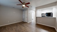 Located at 6313 Evers Road in Leon Valley, TX, this efficiently designed single-story, 1-bedroom, 1-bathroom home makes excellent use of its compact footprint. Rich wood-look flooring runs throughout, providing a warm and cohesive aesthetic across all rooms.

The open-concept living area is bright and inviting, featuring neutral gray walls, clean white baseboards, and a ceiling fan with integrated lighting. The layout flows naturally into the kitchen, which is separated by a half-wall breakfast bar with a dark countertop. The kitchen is outfitted with white shaker-style cabinetry and modern appliances, maximizing both storage and functionality.

The bedroom offers a comfortable and quiet retreat, benefiting from a ceiling fan, natural light from a window with blinds, and the same warm hardwood-style flooring found throughout the home. An electrical panel is conveniently housed within the room.

The full bathroom is clean and well-appointed, featuring a white shaker-style vanity with a light countertop, a large mirror, brushed nickel fixtures, and a tiled shower-tub combination. Additional spaces include a hallway, a closet for storage, and a dedicated utility room. The home's straightforward, single-floor layout ensures easy navigation and practical everyday living.