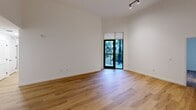 This North Miami apartment offers a generous 1720 square feet of living space, including five bedrooms and two bathrooms. The primary bedroom is particularly spacious at 370 square feet. The modern kitchen is a highlight, featuring sleek white and wood-toned cabinetry, stainless steel appliances, and under-cabinet lighting. A central island provides additional workspace and casual dining options.

The bathrooms are elegantly appointed, with one showcasing a marble-inspired design, illuminated mirror, and a combination tub-shower. Throughout the apartment, warm wood flooring creates a cohesive and inviting atmosphere. The bedrooms are well-proportioned, with ample closet space featuring wire shelving systems for organization.

Large windows and sliding glass doors allow natural light to flood the rooms, enhancing the sense of space. The apartment is part of a larger complex that boasts beautiful tropical landscaping, including palm trees and manicured gardens, visible from private balconies. This creates a resort-like ambiance for residents to enjoy. The single-story layout and open floor plan contribute to a comfortable and accessible living environment, ideal for families or those who appreciate expansive living spaces.
