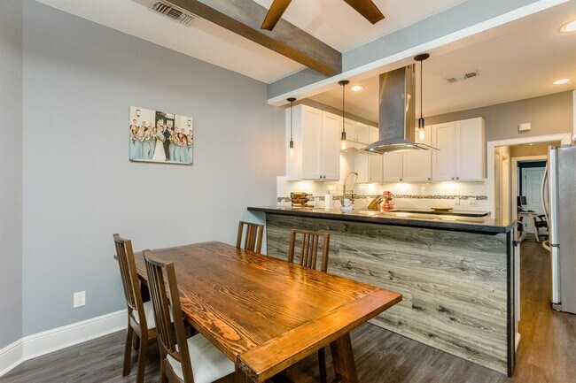 Open Kitchen and Dining area. The breakfast bar has a wood panel detail. - 732 E 12th 1/2 St