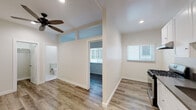 Located at 2025 East 4th St in the heart of Los Angeles, this single-floor unit delivers a clean, modern aesthetic with thoughtful updates throughout. Warm wood-look laminate flooring runs continuously across the living spaces, creating a cohesive and inviting feel.

The kitchen is a standout feature, outfitted with crisp white shaker cabinetry, dark countertops, a stainless steel gas range, refrigerator, and an under-cabinet range hood. A window allows natural light to fill the space, and recessed lighting adds to the bright, functional atmosphere.

The living and bedroom areas are finished with neutral white walls and ceiling fans, promoting comfort and airflow. The bedroom includes access to a dedicated closet with built-in shelving, offering organized storage. Transom-style windows above interior doorways enhance the sense of openness between rooms.

The bathroom is elegantly finished with large-format marble-look tile covering both the floor and the tub surround, giving it a polished, upscale appearance. A soaking tub with a showerhead, a white vanity with an integrated sink, and a frosted window for natural light complete the space.

Throughout the unit, clean lines, recessed lighting, and consistent finishes reflect a thoughtfully refreshed interior, making this Los Angeles property a well-maintained and move-in-ready space.