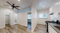 Located at 2025 East 4th St in the heart of Los Angeles, this single-floor unit delivers a clean, modern aesthetic with thoughtful updates throughout. Warm wood-look laminate flooring runs continuously across the living spaces, creating a cohesive and inviting feel.

The kitchen is a standout feature, outfitted with crisp white shaker cabinetry, dark countertops, a stainless steel gas range, refrigerator, and an under-cabinet range hood. A window allows natural light to fill the space, and recessed lighting adds to the bright, functional atmosphere.

The living and bedroom areas are finished with neutral white walls and ceiling fans, promoting comfort and airflow. The bedroom includes access to a dedicated closet with built-in shelving, offering organized storage. Transom-style windows above interior doorways enhance the sense of openness between rooms.

The bathroom is elegantly finished with large-format marble-look tile covering both the floor and the tub surround, giving it a polished, upscale appearance. A soaking tub with a showerhead, a white vanity with an integrated sink, and a frosted window for natural light complete the space.

Throughout the unit, clean lines, recessed lighting, and consistent finishes reflect a thoughtfully refreshed interior, making this Los Angeles property a well-maintained and move-in-ready space.