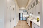 This thoughtfully designed single-floor residence accommodates four bedrooms, one bathroom, a living room, kitchen, and hallway within a compact and well-organized layout. Light wood flooring flows consistently throughout, lending warmth and visual continuity across all spaces.

The galley-style kitchen is a standout feature, outfitted with crisp white shaker cabinetry — including tall pantry storage and upper glass-front cabinets — paired with quartz countertops, a subway tile backsplash, and a full suite of stainless steel appliances including a gas range, built-in microwave, dishwasher, and French door refrigerator.

The living room benefits from tall windows that draw in generous natural light, creating an airy and open atmosphere. The bathroom is finished in a clean, contemporary style with a white vanity, quartz countertop, and a backlit wall mirror.

The primary bedroom features a ceiling fan, a window with outdoor views, and ample wall space. The remaining bedrooms vary in size — each with a window for natural light — and one bedroom offers convenient access to an in-unit stacked washer and dryer. Neutral wall tones and consistent trim details throughout give the entire residence a cohesive, modern aesthetic.